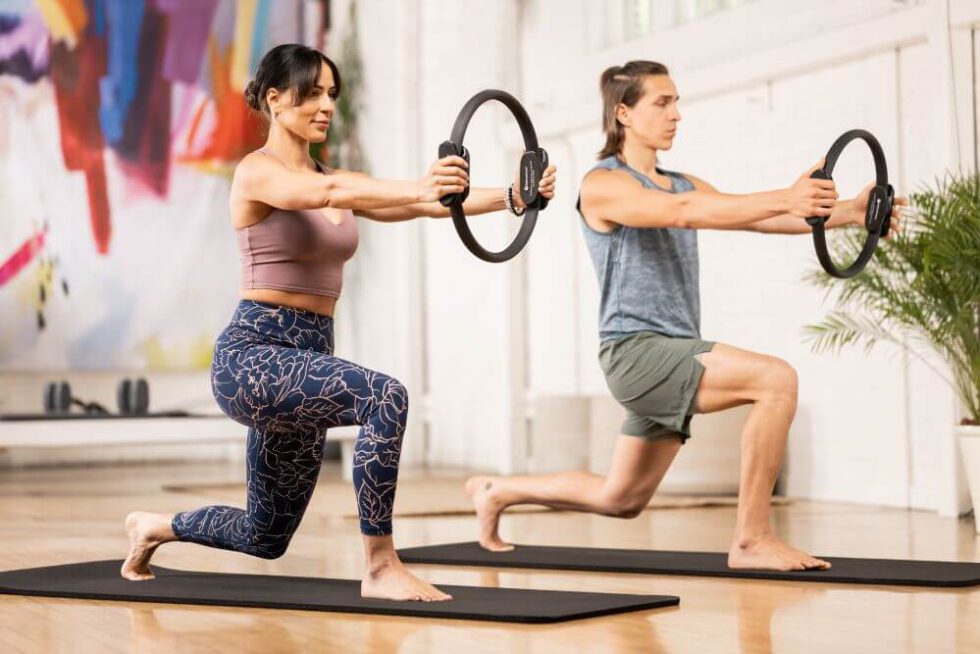 Two people performing lunges with Ultra-Fit Circle in a studio.
