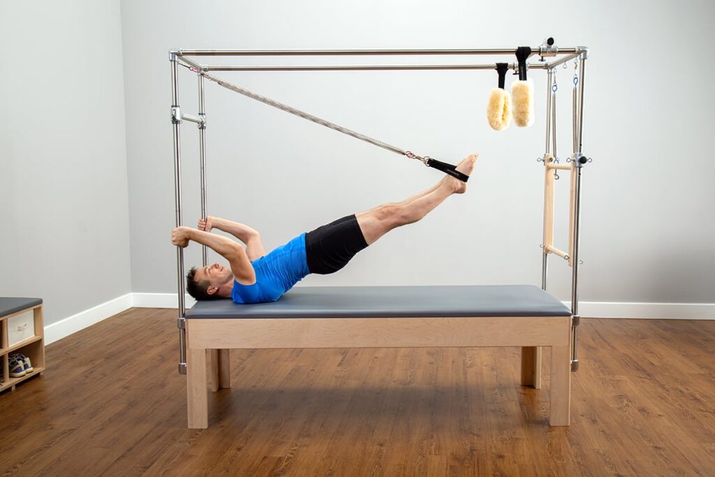 Man exercising on CenterLine Cadillac Pilates machine.