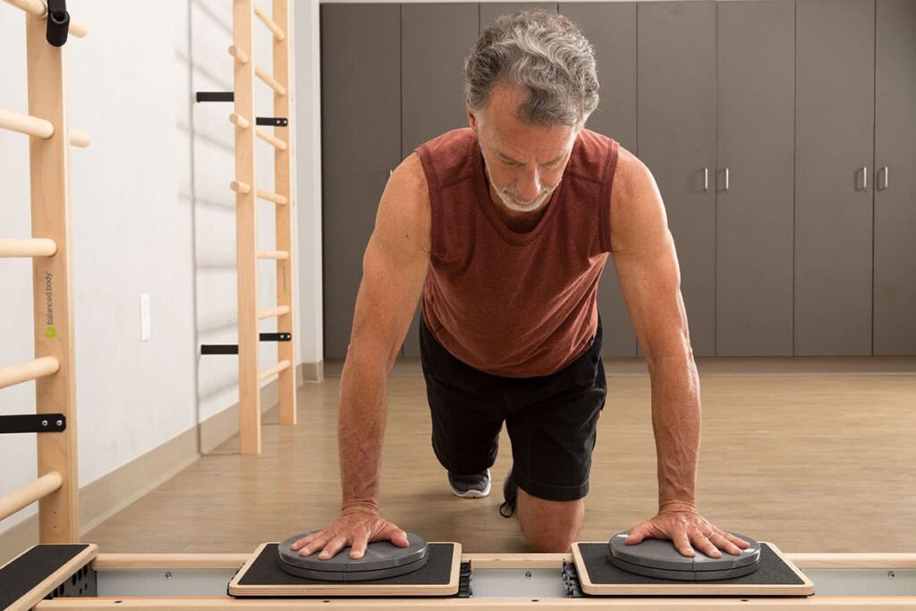 Man using CoreAlign for plank exercise in Pilates studio