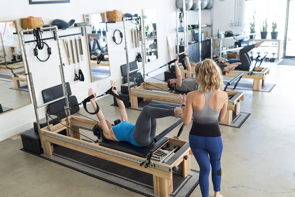 Pilates session using Clinical Reformers with Tower in studio.