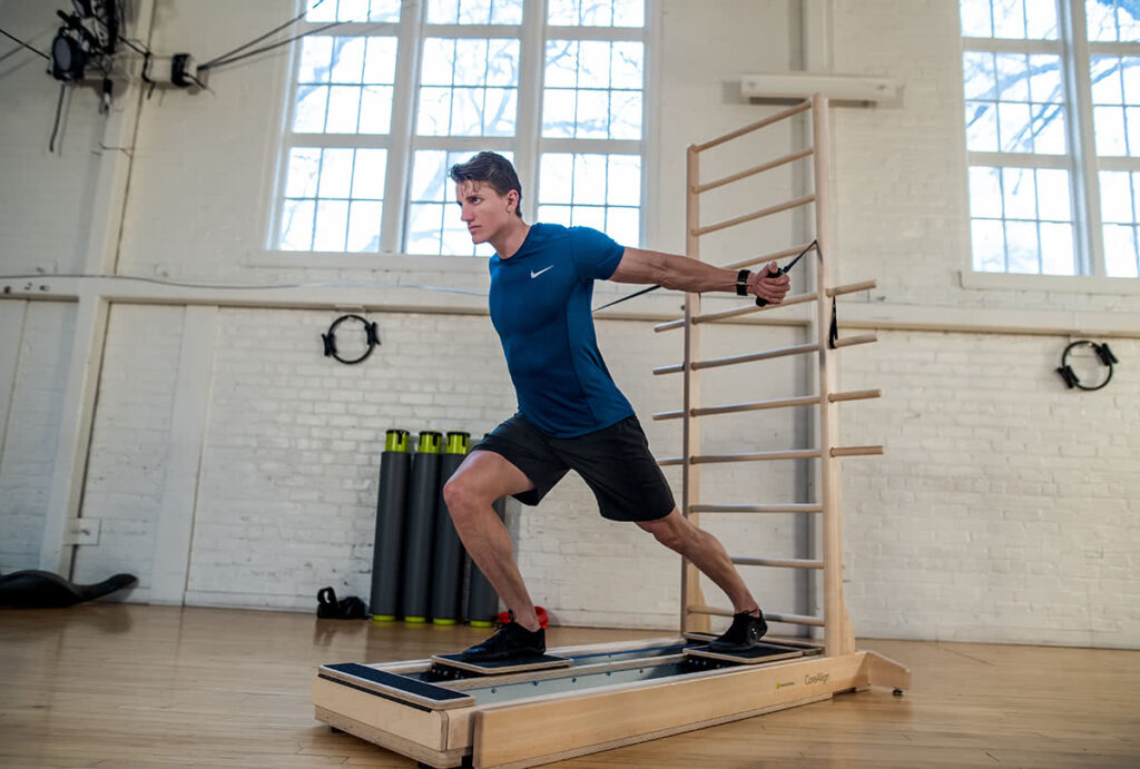 Man exercising on CoreAlign with wall ladder in studio.