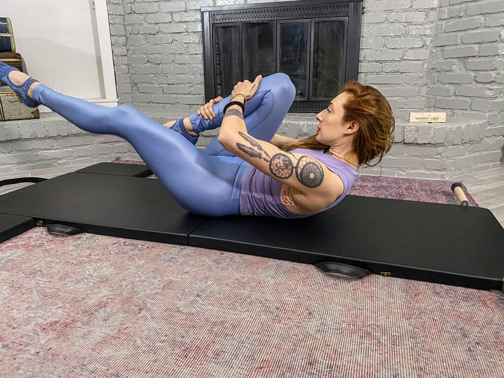 Person exercising on Contrology Folding Mat in Pilates studio.