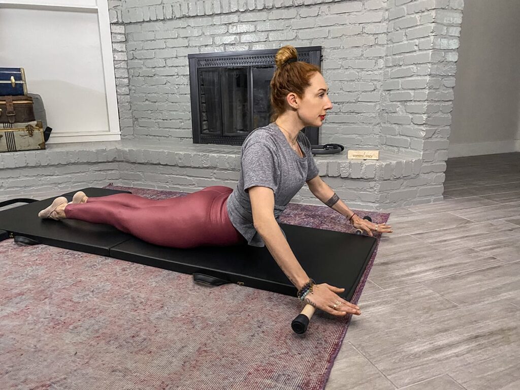 Woman practicing Pilates on a Contrology Folding Mat indoors.