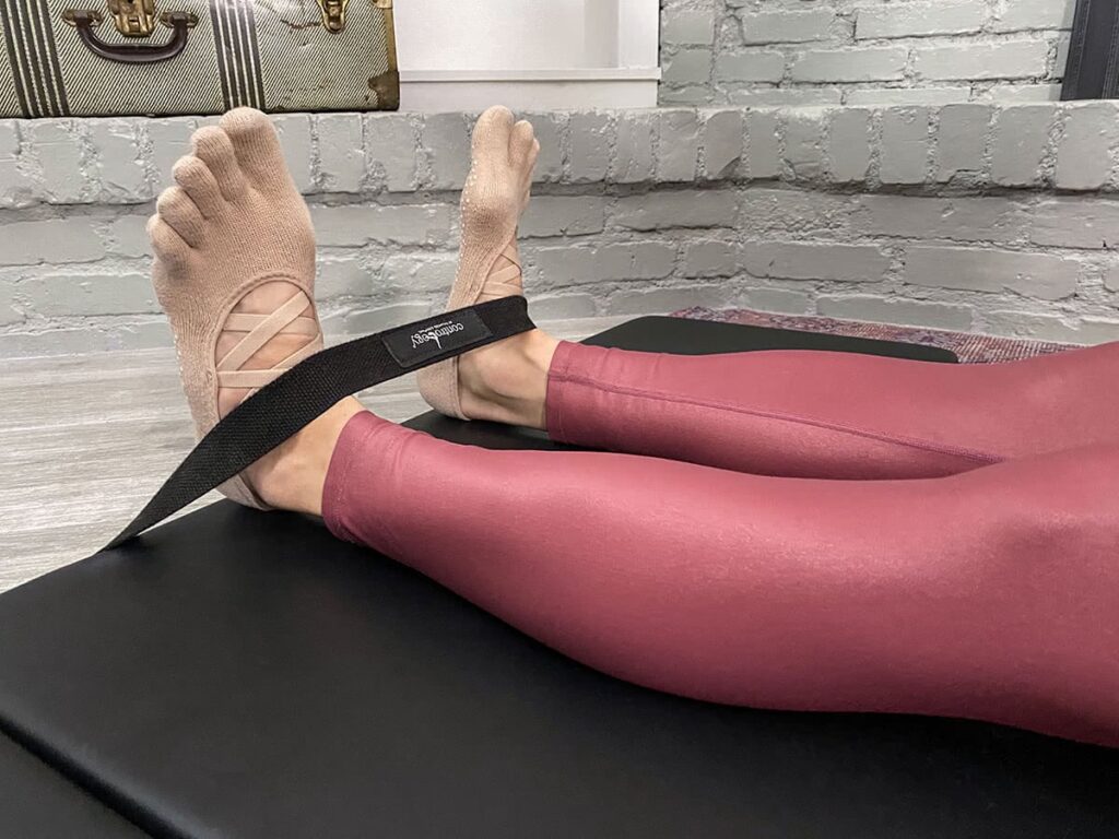 Pilates foot strap on Contrology Folding Mat with feet in grip socks