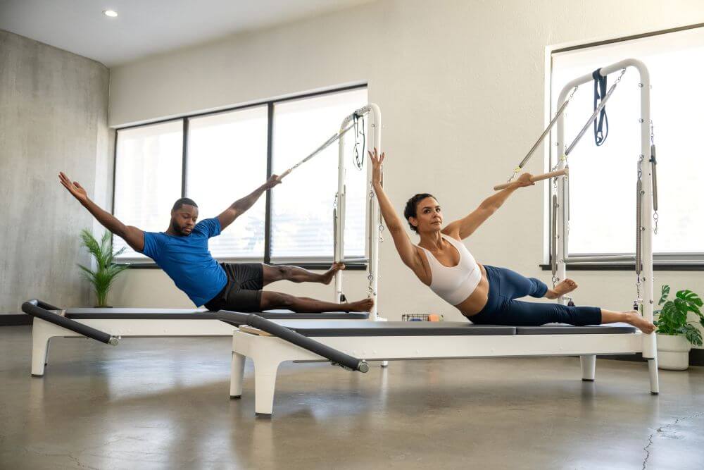 People exercising on Allegro 2 Tower of Power in a bright studio.