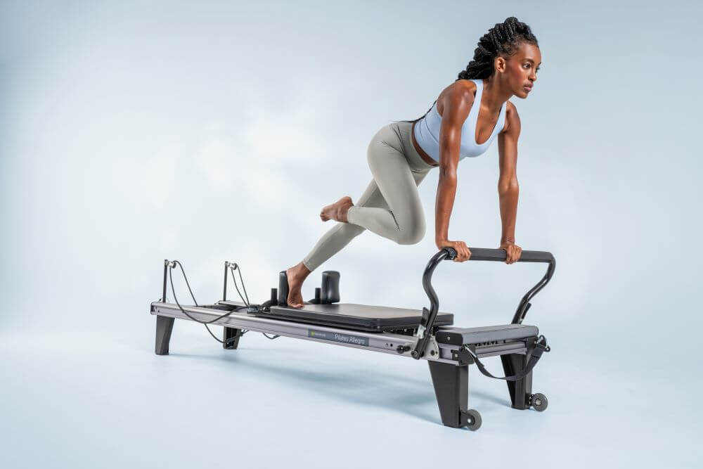 Woman exercising on Allegro Reformer Pilates machine.