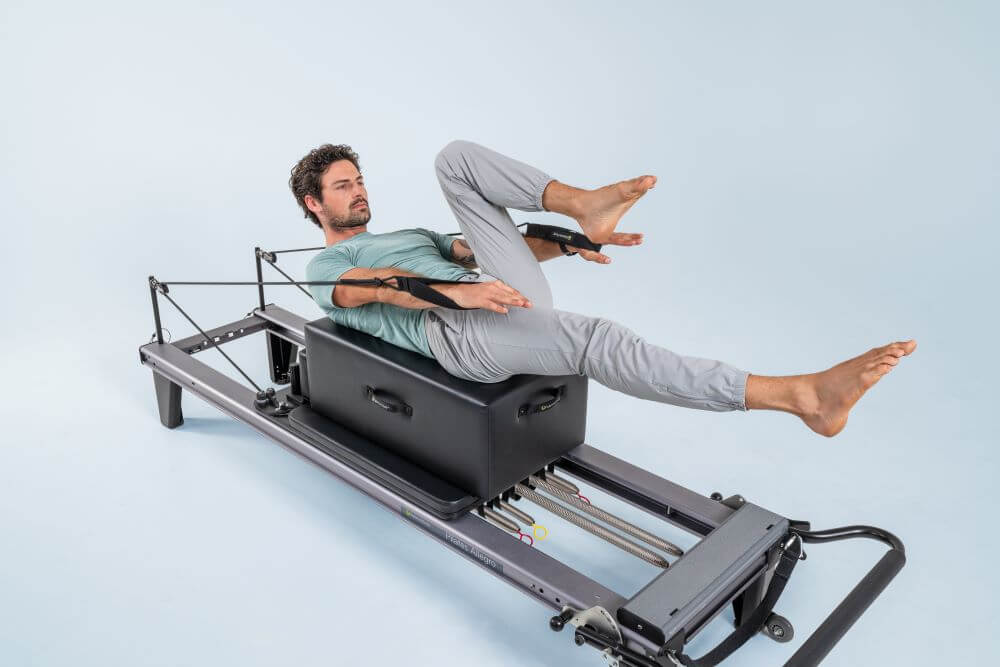 Person demonstrating exercise on Allegro Reformer Pilates machine.