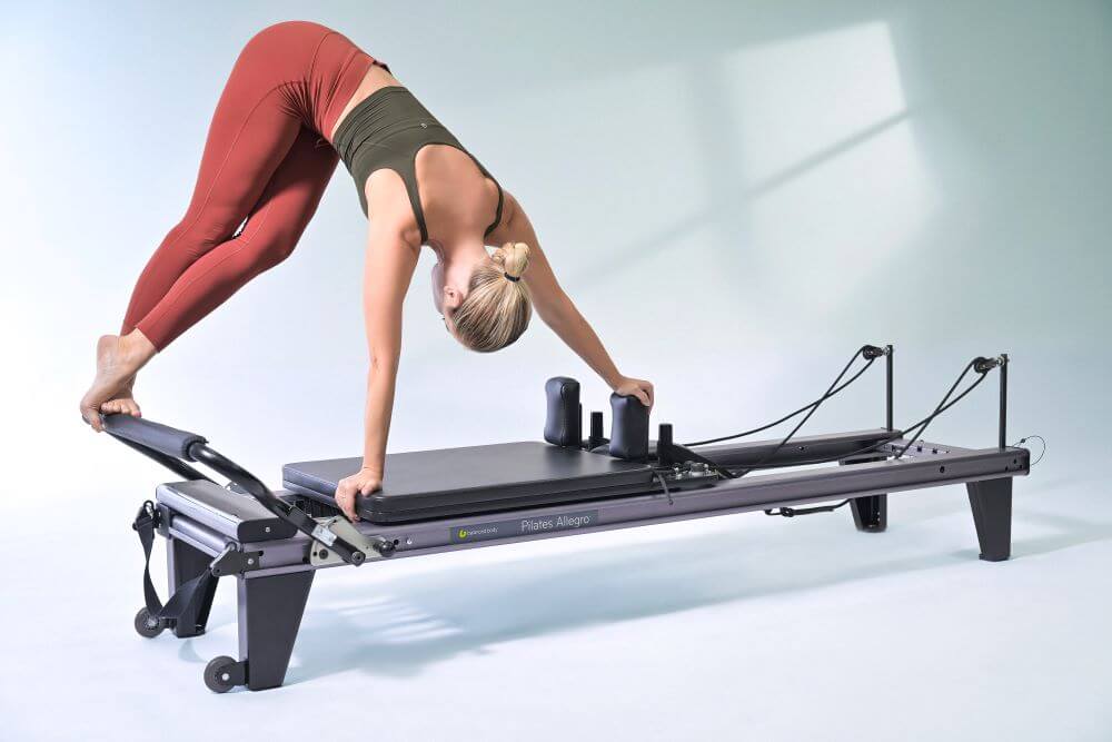 Person exercising on Allegro Reformer Pilates machine