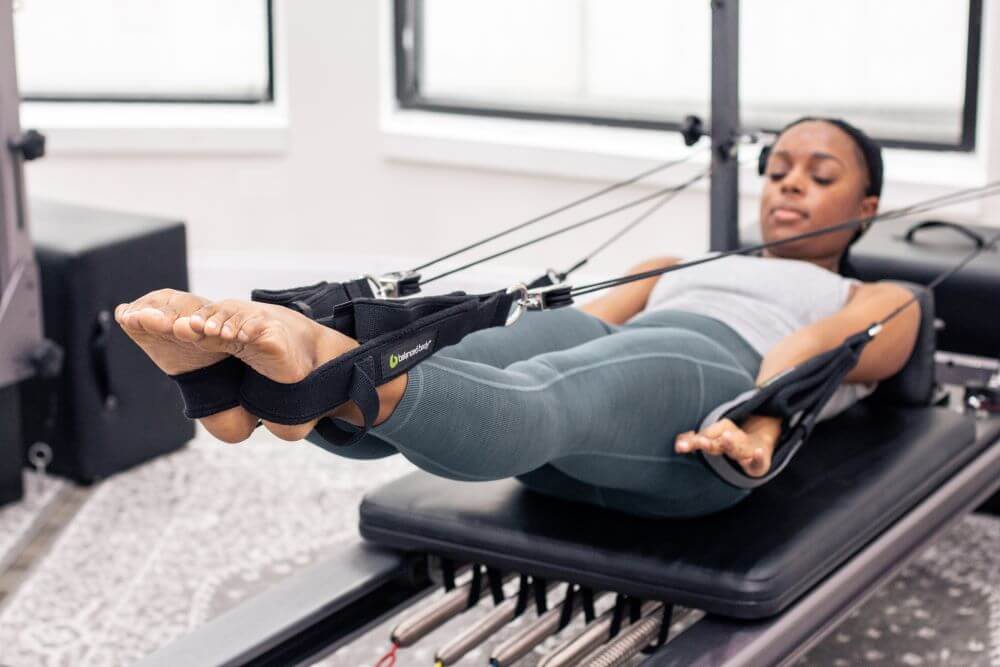 Person using Allegro Reformer Konnector for Pilates exercise