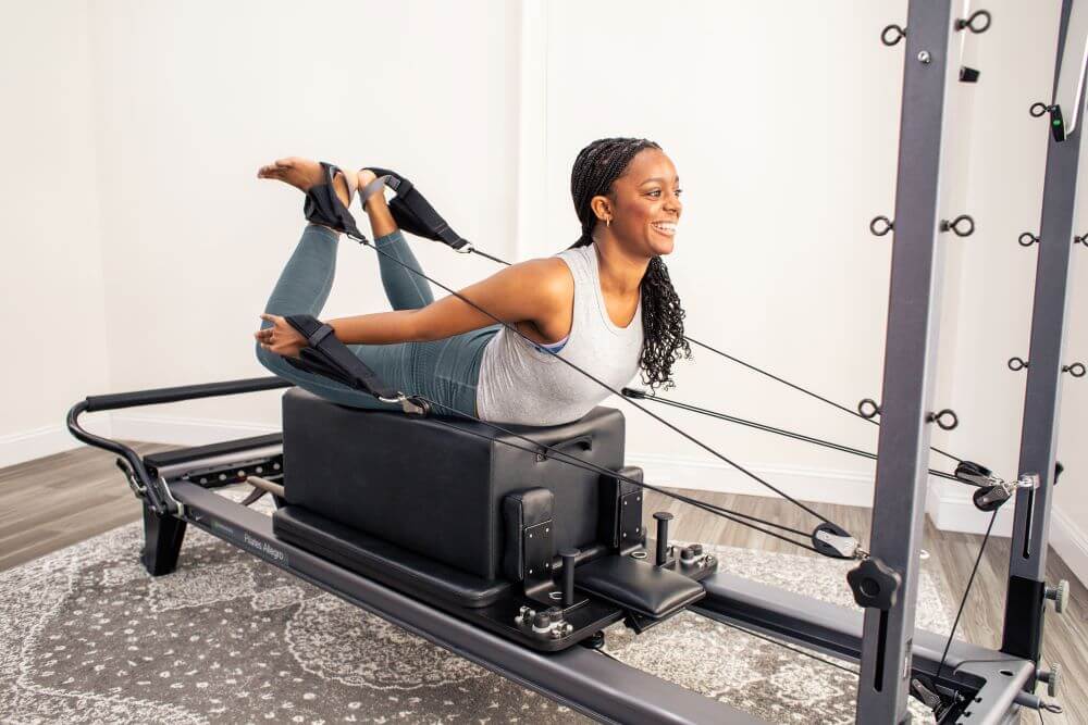 Person using Allegro Reformer Konnector for Pilates exercise.