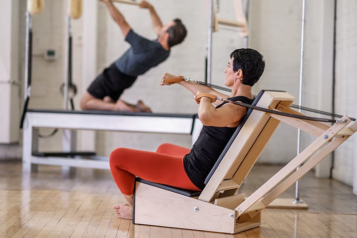 Person exercising on Contrology Arm Chair in Pilates studio.