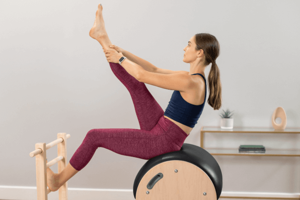 Pilates exercise on Ladder Barrel with adjustable sliding base.