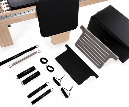 Pilates reformer accessories: sitting box, foot platform, jumpboard, loops, cuffs, handles, foot strap.
