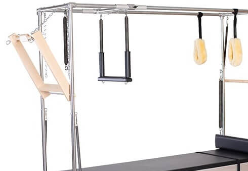 Pilates equipment with wooden push-through bar and accessories.