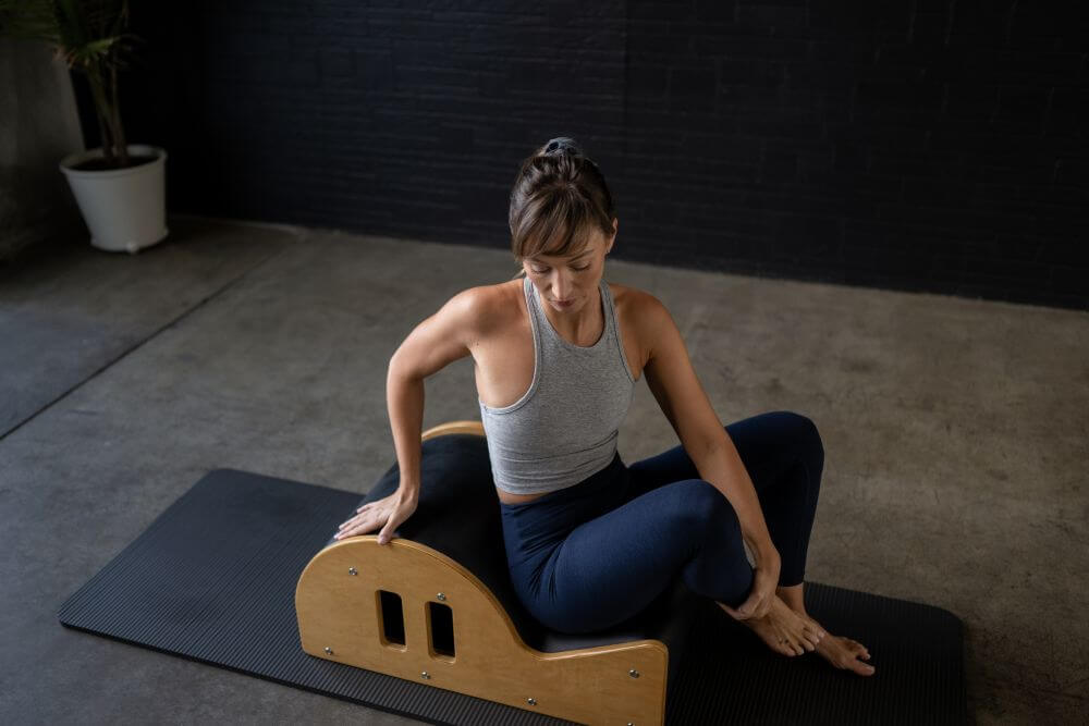 Pilates instructor using Clara Step Barrel on a mat.