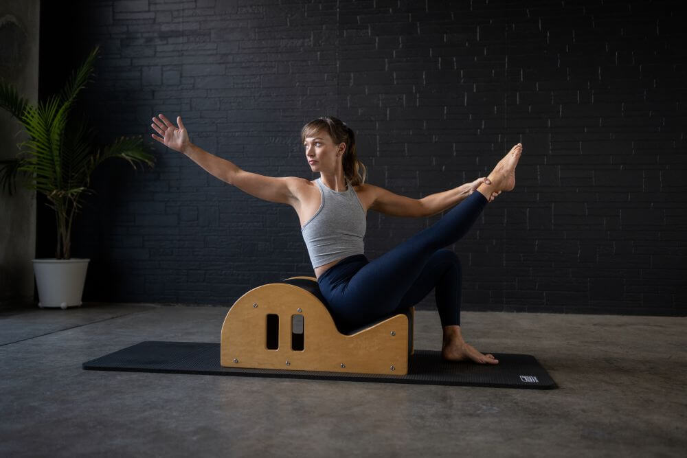 Person exercising on Clara Step Barrel with cut-out handholds.