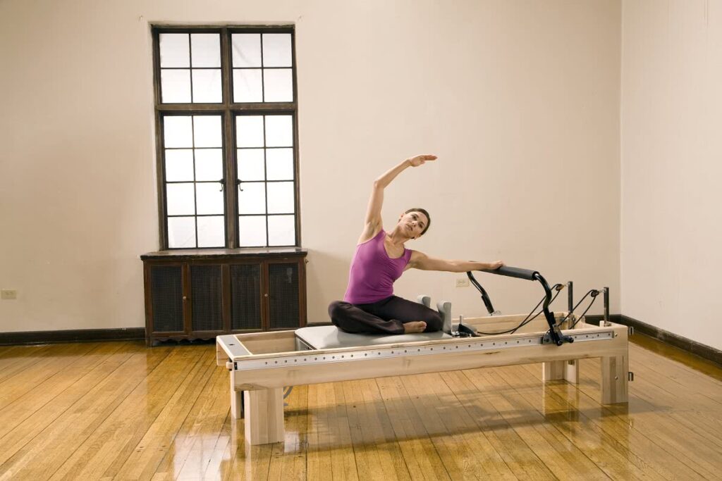 Woman practicing Pilates on Clinical Reformer in a studio.