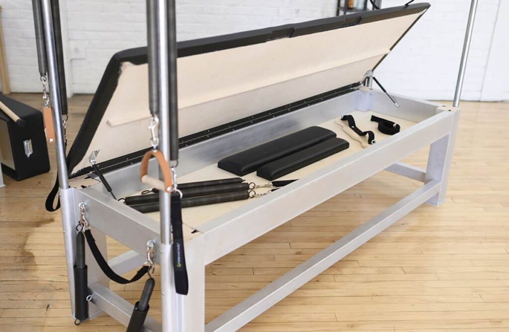 Contrology Cadillac open toybox with Pilates accessories inside.