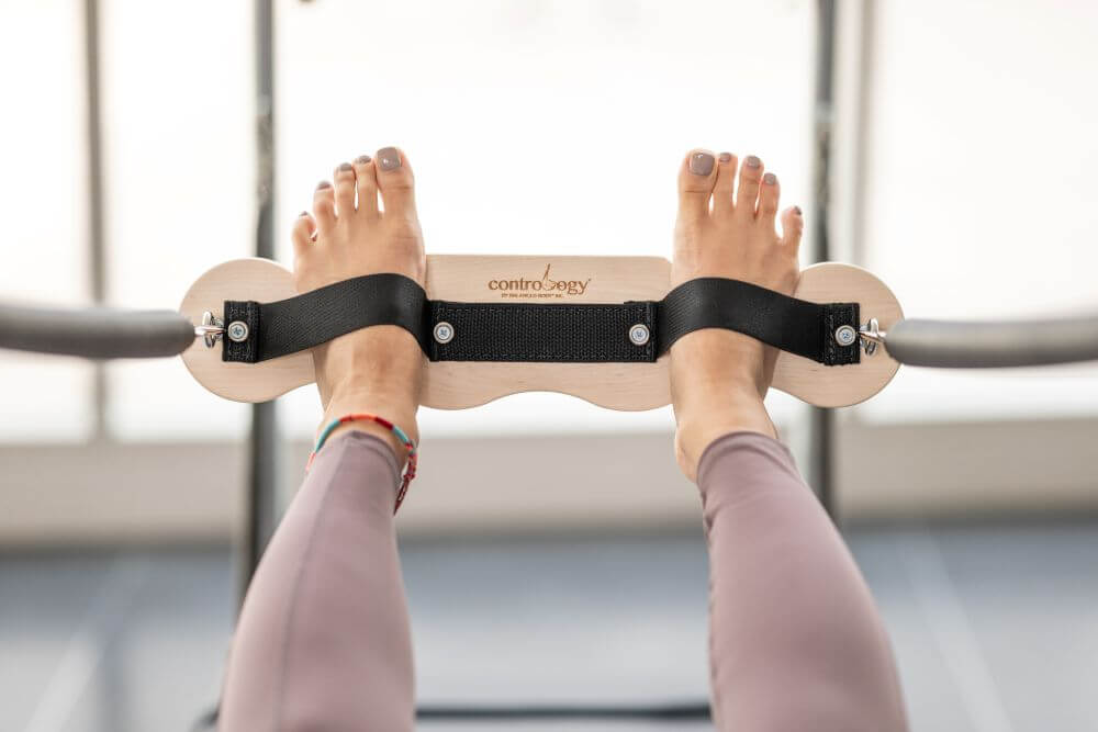 Contrology Airplane Board with foot straps for Pilates.