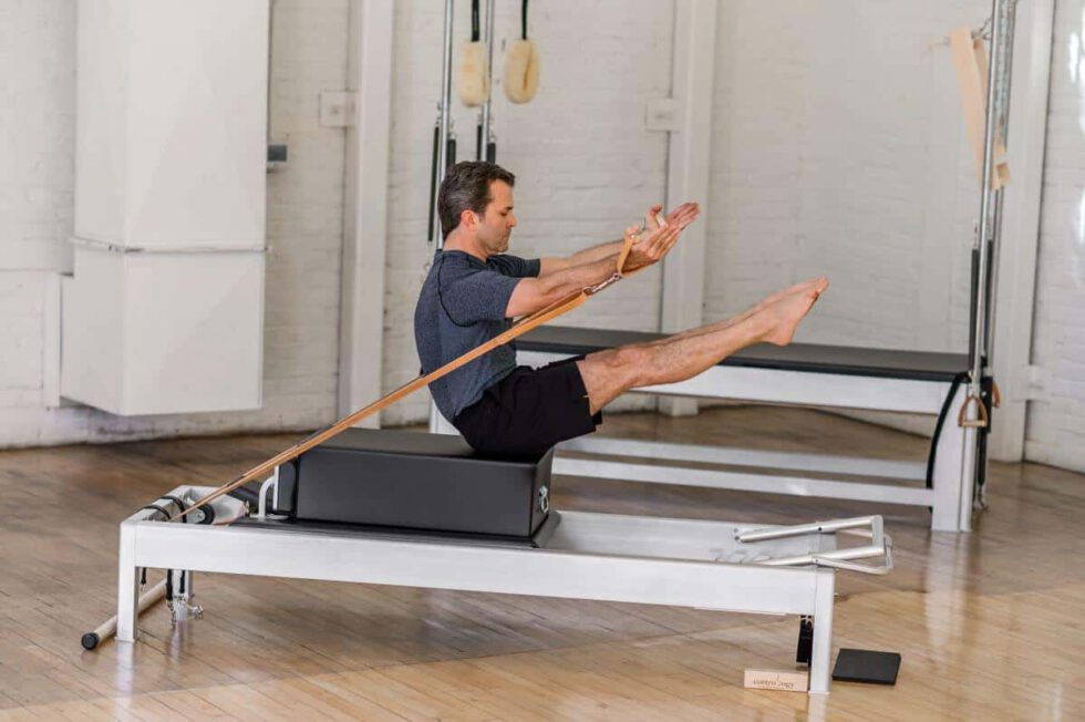 Man performing exercise on the Contrology Box in a Pilates studio.