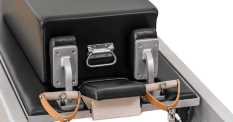 Black classic Pilates box with metal handles on Contrology Reformer.
