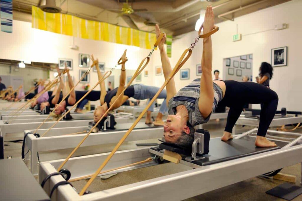 Pilates class using Contrology Leather Handles for exercises.