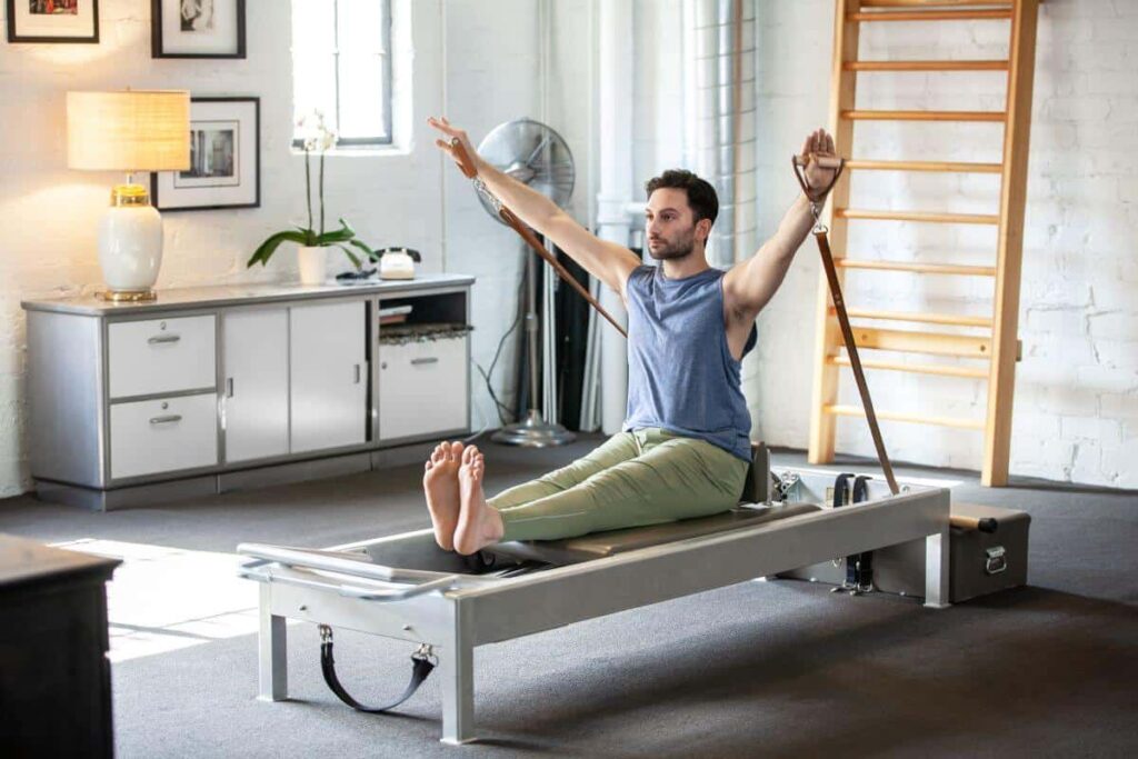Man using Contrology Leather Handles on Pilates reformer.