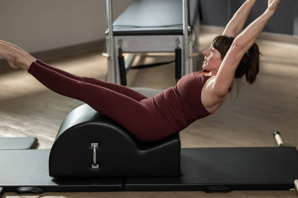Woman exercising on the Contrology Spine Corrector in studio.