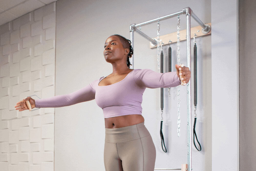 Person exercising with Contrology Wall Tower in a studio.