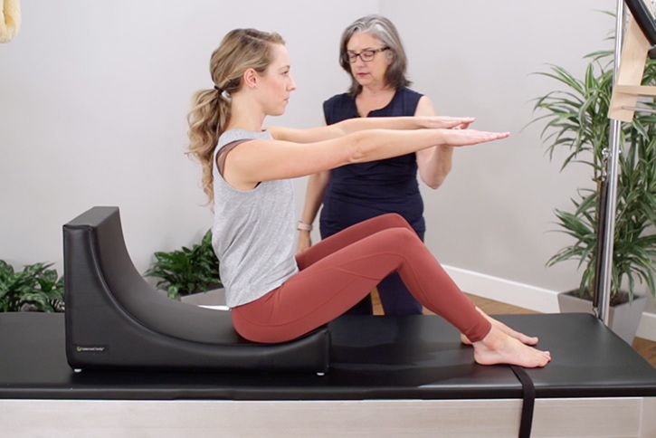Woman using C-Shaper for Pilates with instructor guidance.