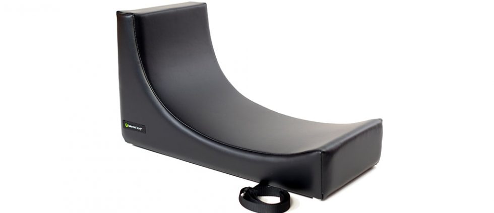 C-shaped Pilates equipment with vinyl upholstery and handles