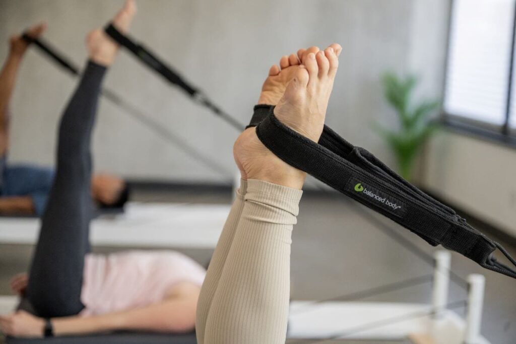 Person using Balanced Body Double Loops on a Pilates reformer.