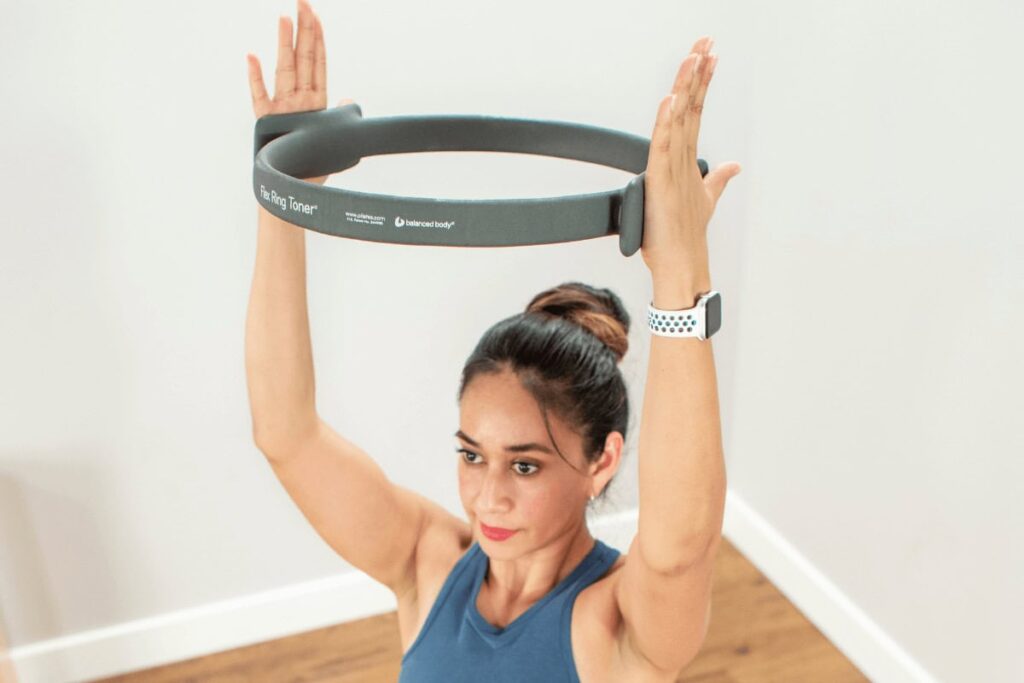 Woman using Flex Ring Toner for Pilates exercise.