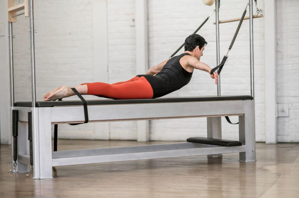 Instructor using Contrology Cadillac with JPack Springs for Pilates