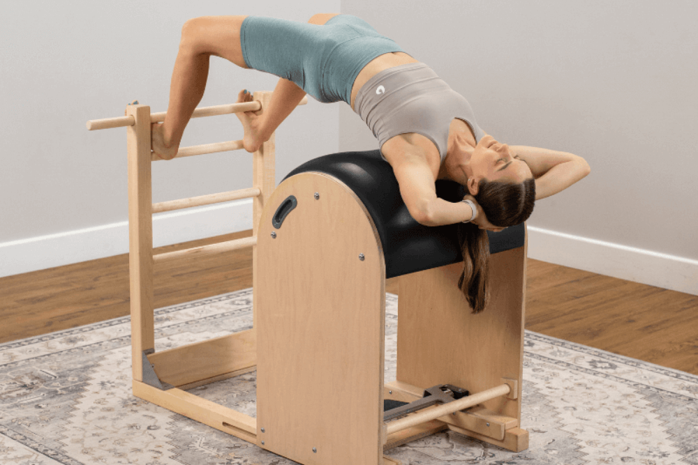 Woman exercising on Ladder Barrel in Pilates studio.