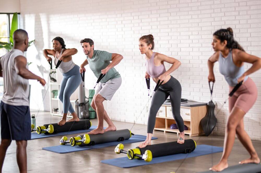 Group Pilates class using MOTR exercise equipment in studio.