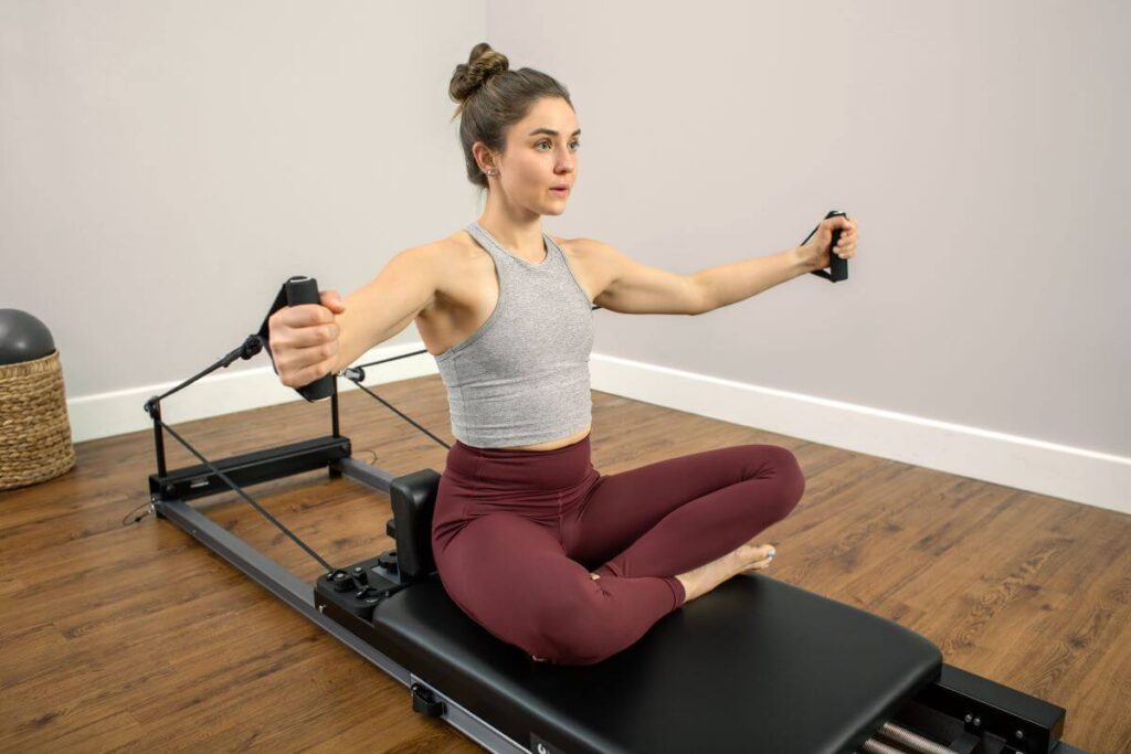Person using Neoprene Handles on Pilates reformer from Balanced Body.