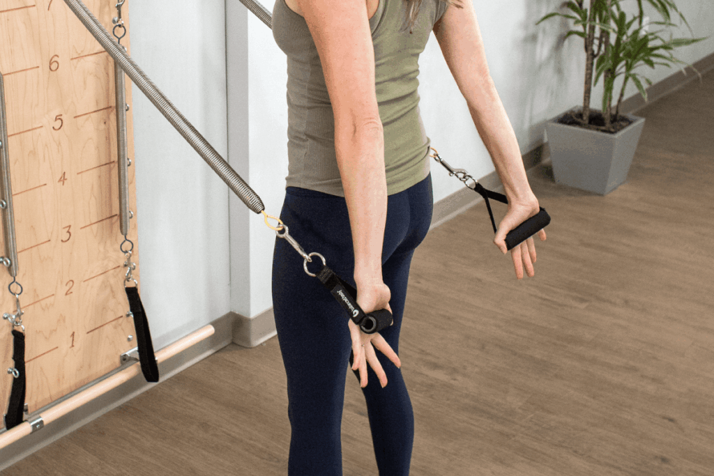 Person using Balanced Body Neoprene Handles in a Pilates workout.