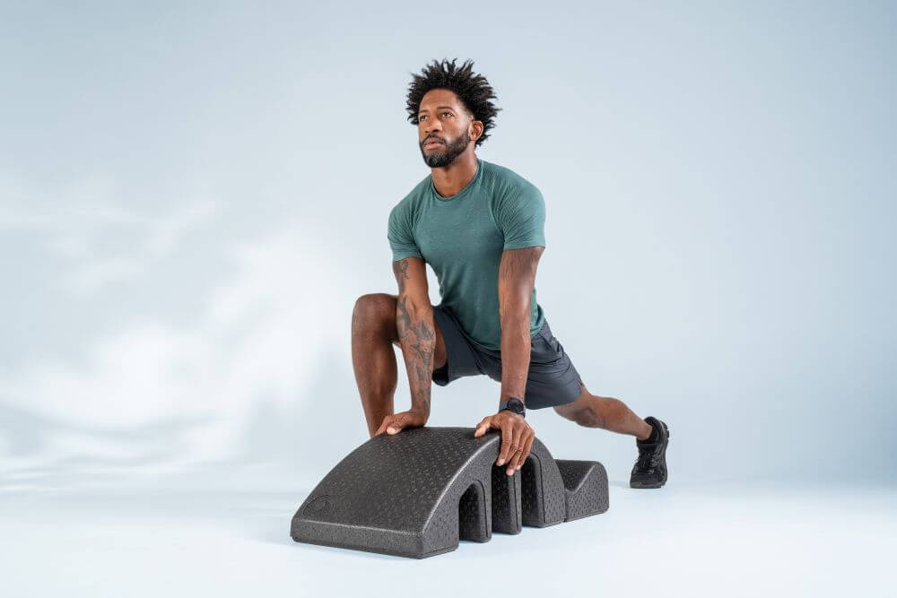 Man using Pilates Arc for stretching and strengthening exercises.