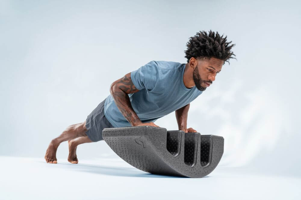 Man exercising with Pilates Arc for spinal strengthening