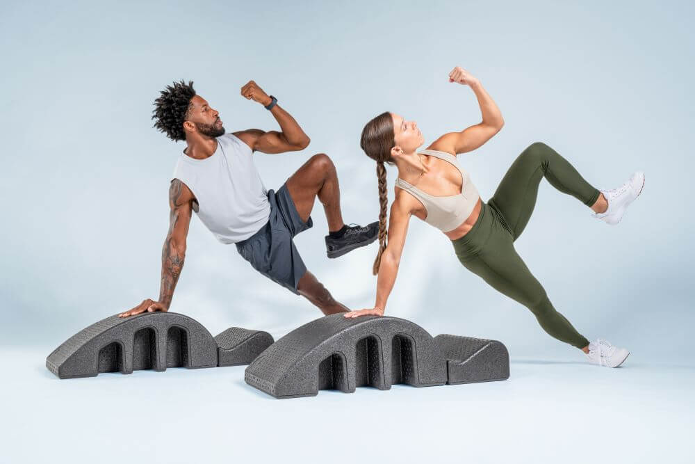 Two people performing exercises on Pilates Arc for core strength.