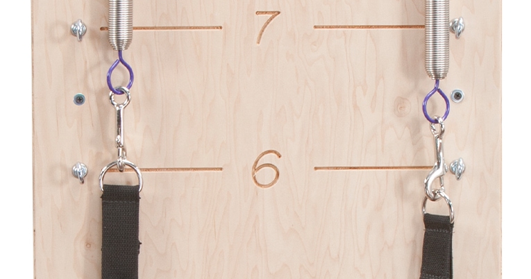 Wall-mounted Pilates equipment with springs and handles for versatile training.