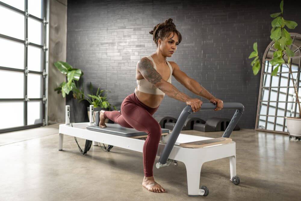 Woman exercising on Allegro 2 Reformer in a modern studio.