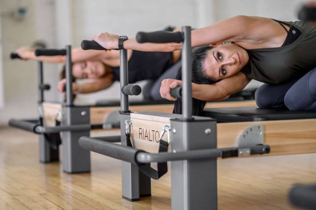 Pilates-harjoitus käyttäen Rialto Reformer -lautoja käsitukena.