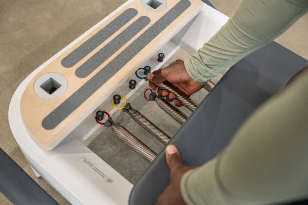 Person adjusting Balanced Body Reformer Signature Springs.