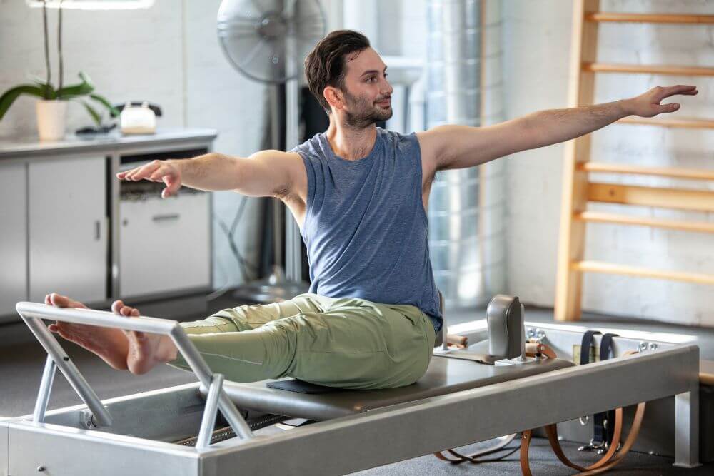 Man exercising on Contrology Reformer Pilates machine.