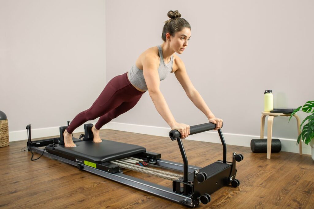 Woman exercising on Pilates Metro IQ Reformer in home setting