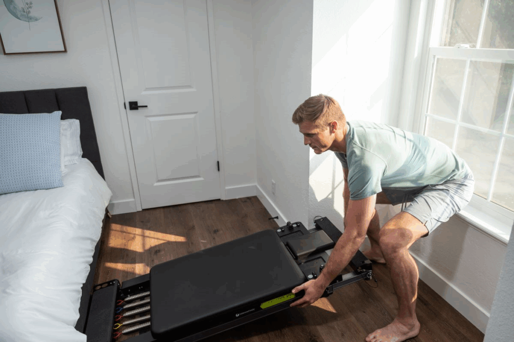 Man adjusting Metro IQ Reformer in a home setting.