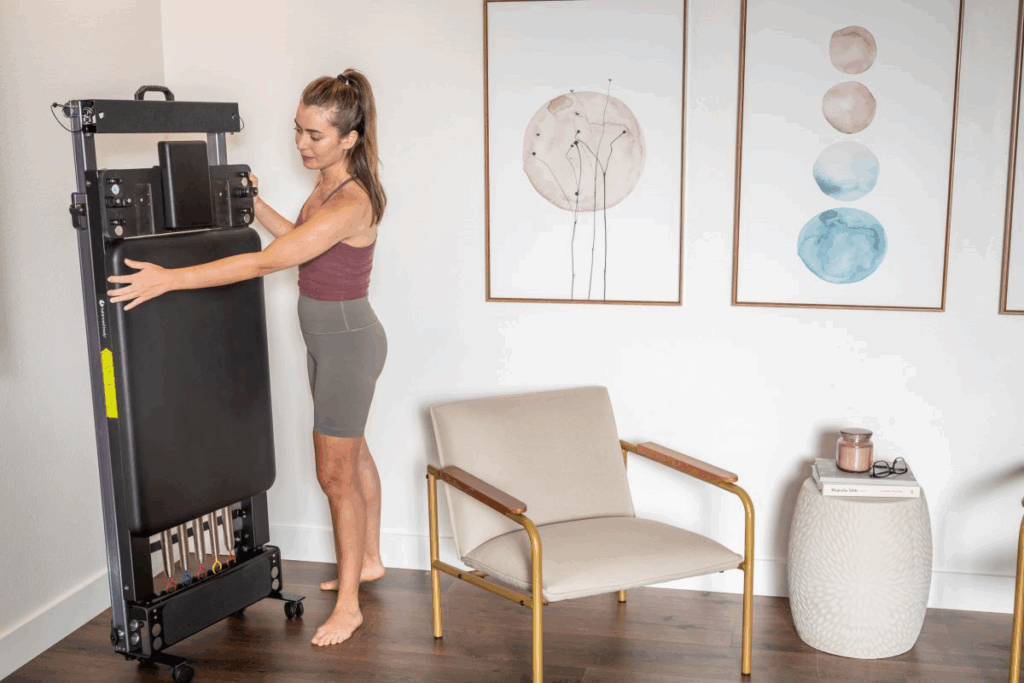 Woman folding Metro IQ Reformer for easy storage in home.