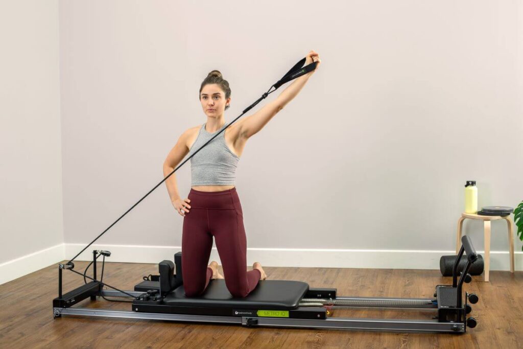 Woman using Reformer Signature Springs for Pilates exercise.